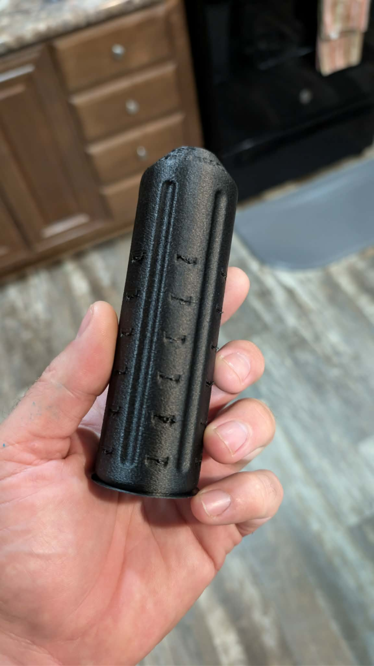 Double Header .22LR suppressor in hand, showing the header-style vents