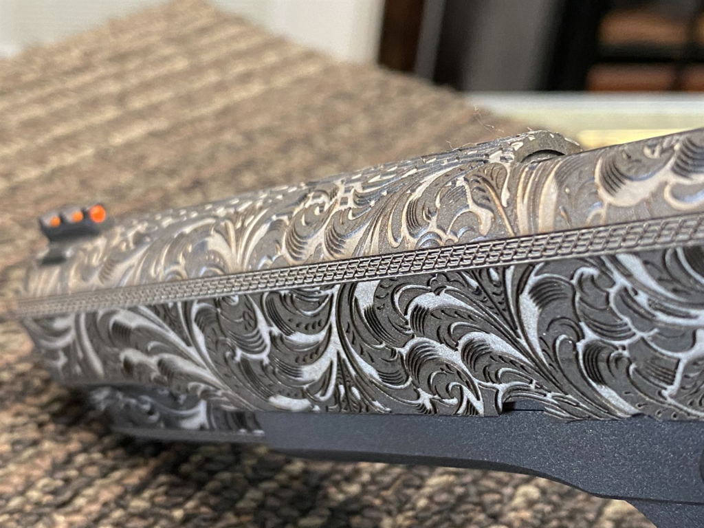 Close-up of scroll engraving on a pistol slide