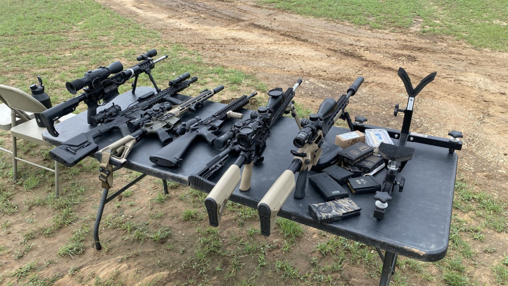 A table full of rifles at the range